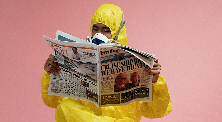 Mann gelber Schutzanzug ließt Zeitung